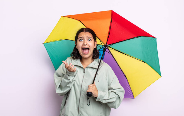 pretty young woman looking desperate, frustrated and stressed. rain and umbrella concept - Foto, Imagem