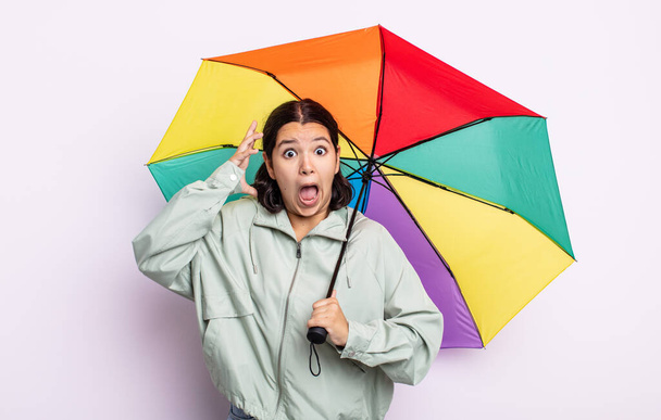 pretty young woman screaming with hands up in the air. rain and umbrella concept - Foto, Imagem