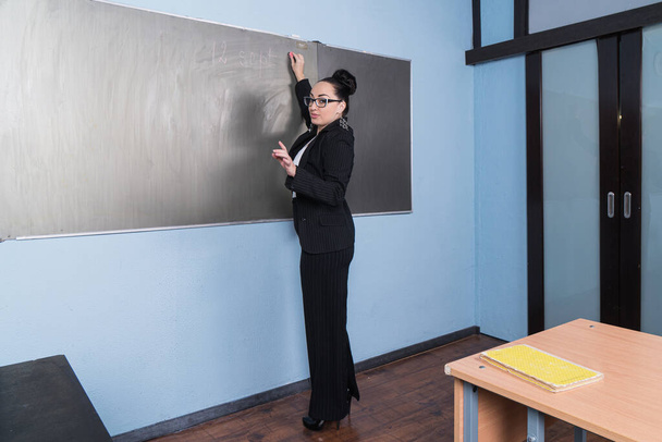 Beautiful confident teacher in a classroom.  - Фото, изображение