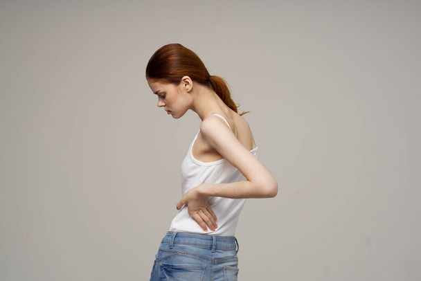 γυναίκα σε λευκό t-shirt με χειροπρακτική ρευματισμούς προβλήματα υγείας φως φόντο. Υψηλής ποιότητας φωτογραφία - Φωτογραφία, εικόνα