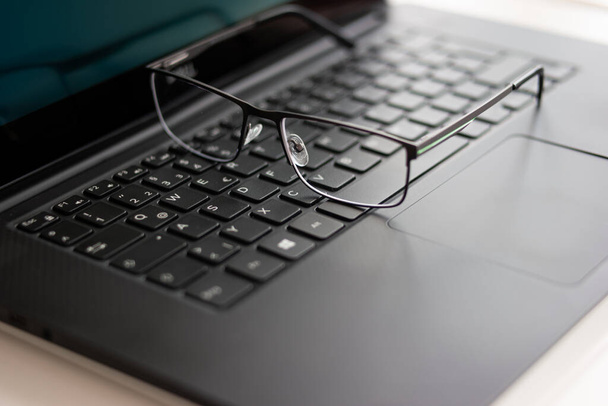 Clear reading glasses, black rim, on a laptop keypad, no people. - Zdjęcie, obraz