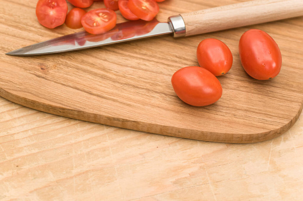datterini tomatoes with chopping board and knife on a wooden surface with text space - Photo, image