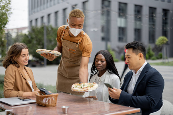 Деловая команда обедает в кафе на открытом воздухе - Фото, изображение