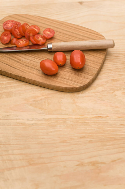 datterini tomatoes with chopping board and knife on a wooden surface with text space - Fotografie, Obrázek