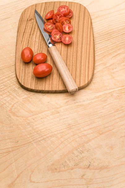 datterini tomatoes with chopping board and knife on a wooden surface with text space - Foto, imagen