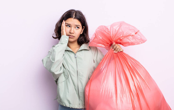 pretty young woman feeling bored, frustrated and sleepy after a tiresome. trash bag concept - Foto, afbeelding