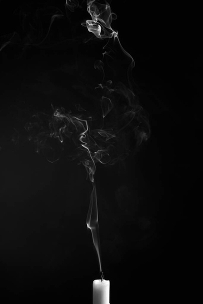 A vertical shot of the smoke of an extinguished candle isolated on a black background - Fotó, kép