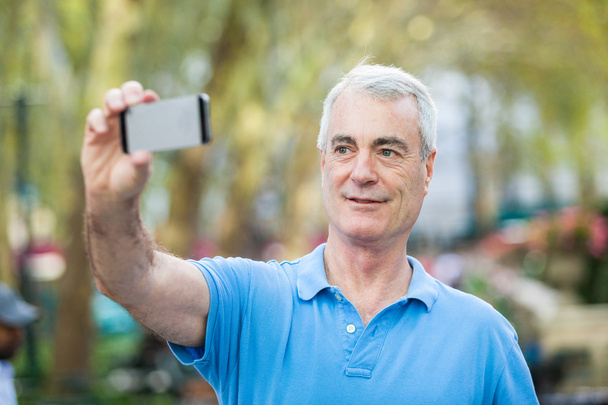 Senior Man Taking a Selfie at Park - Photo, image