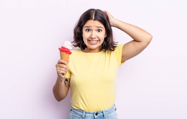 pretty young woman feeling stressed, anxious or scared, with hands on head. ice cream concept - Foto, afbeelding