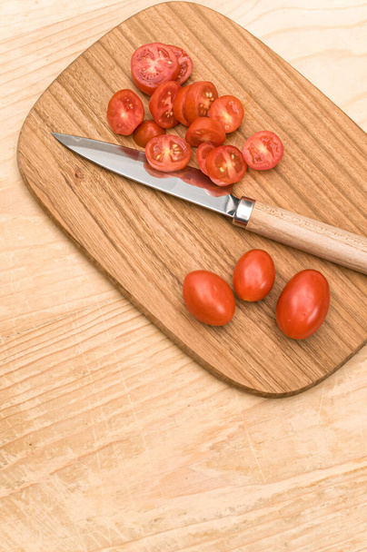 datterini tomatoes with chopping board and knife on a wooden surface with text space - Foto, immagini