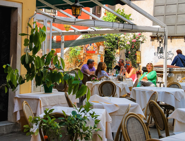 Los turistas descansan en las mesas de un café al aire libre en Venecia, Italia
 - Foto, Imagen