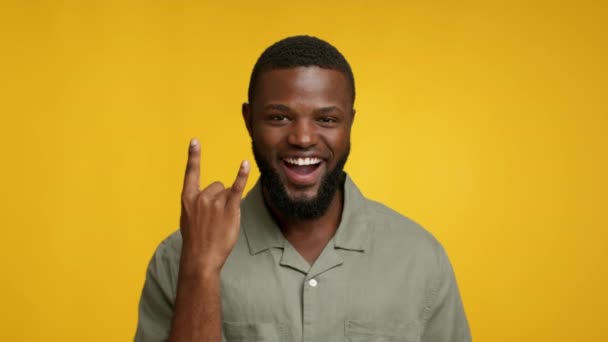 Χαρούμενος νεαρός μαύρος τύπος που δείχνει το Rock and Roll Gesture στην κάμερα - Πλάνα, βίντεο