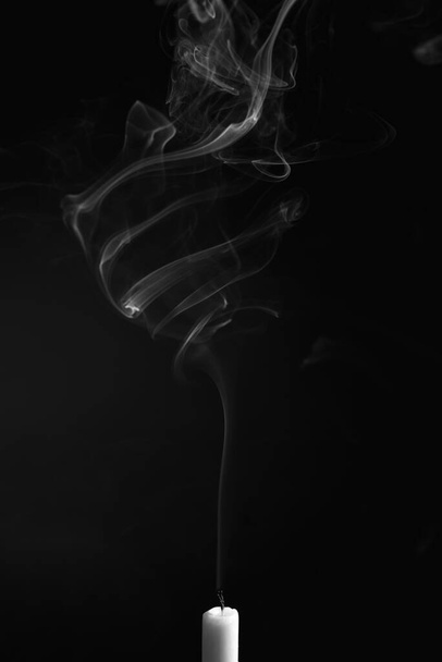 A vertical shot of the smoke of an extinguished candle isolated on a black background - Foto, Imagem