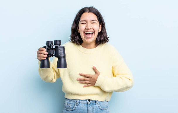 pretty young woman laughing out loud at some hilarious joke. binoculars concept - Foto, Imagen