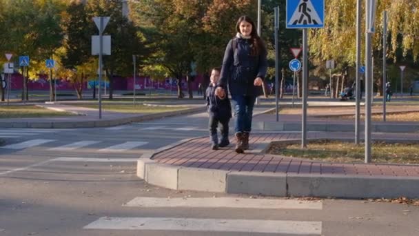 Anya és a gyerek átkelnek az úton a zebránál.. - Felvétel, videó