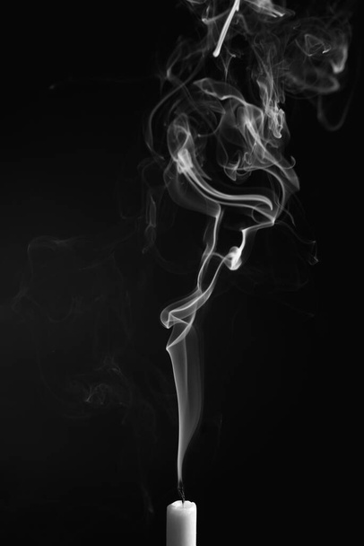 A vertical shot of the smoke of an extinguished candle isolated on a black background - Fotografie, Obrázek