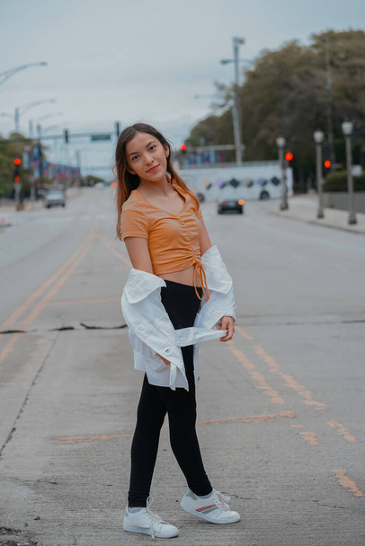 A vertical of a  stylish young beautiful Hispanic female posing on the road - Zdjęcie, obraz