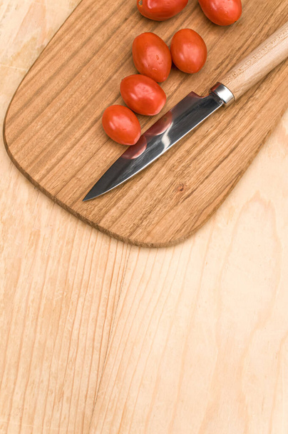 tomates datterini com tábua de corte e faca em uma superfície de madeira com espaço de texto - Foto, Imagem