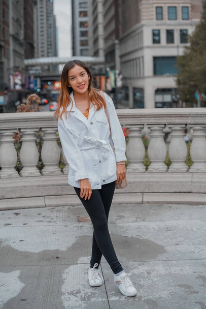 A vertical of a cheerful stylish young beautiful Hispanic female posing on the street - Foto, Imagem