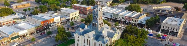 パノラマの空中ビュー歴史的なフッド郡庁舎とクロックタワーダウンタウンのグランベリー、テキサス州、アメリカ。小さな町の広場ユニークなブティック、ビストロ、緑と訪問者のための座席 - 写真・画像