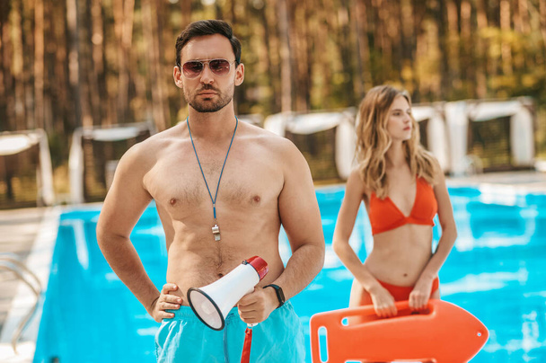 Two pool lifeguards standing near the public pool - Photo, image