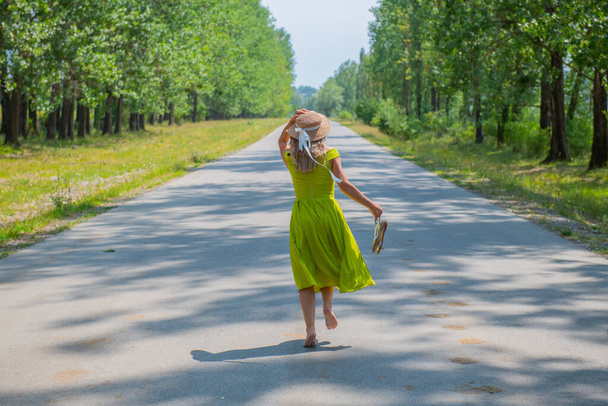 a traveler in a hat runs barefoot on the road. High quality photo - Foto, Bild