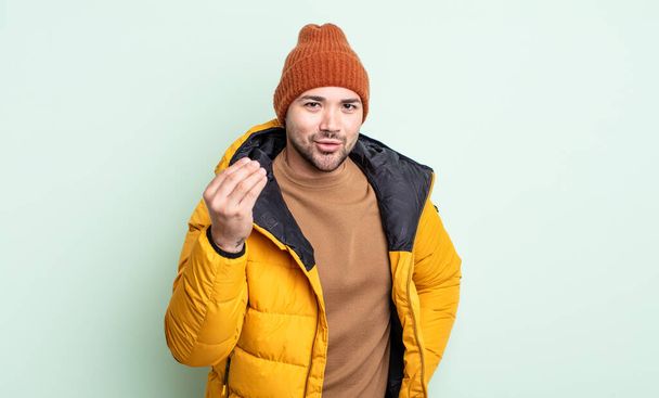 young handsome man making capice or money gesture, telling you to pay. cold weather concept - Фото, зображення