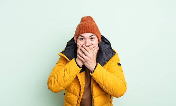 young handsome man covering mouth with hands with a shocked. cold weather concept - Foto, afbeelding