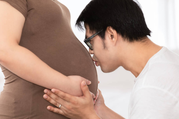 pregnant woman and her husband asia happy smiling while spending time together in the white bedroom and window light background baby love care concept - Foto, Imagem