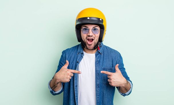 young handsome man feeling happy and pointing to self with an excited. motorbike helmet concept - 写真・画像
