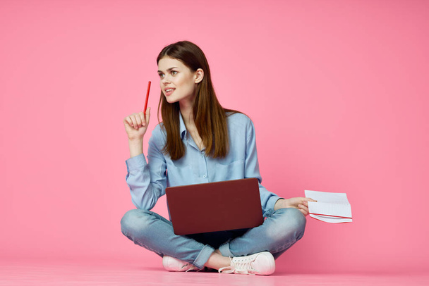 woman sitting on floor with laptop shopping entertainment pink background - Foto, imagen
