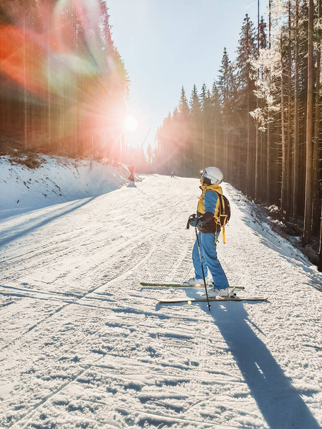 femme dans l'équipement à la piste de ski rayons du soleil passent par la pente - Photo, image