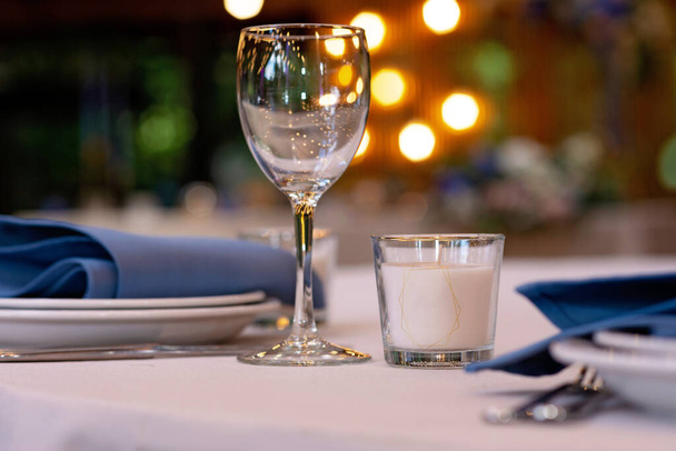Святкове весілля, обстановка столу з синіми лляними серветками, свічками. Весільні прикраси. Концепція меню ресторану. М'який вибірковий фокус
. - Фото, зображення