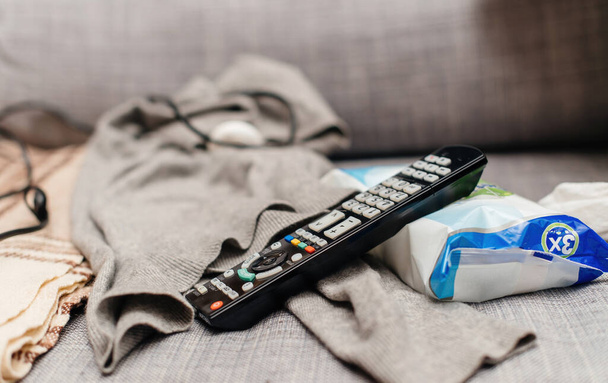 TV remote control on the couch next to the disinfectant - Fotoğraf, Görsel
