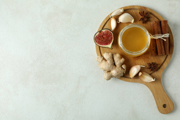 Concept of treatment colds with honey and garlic on white textured background - Foto, Imagen