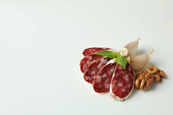 Концепция вкусной еды с колбасой салями на белом фоне - Фото, изображение