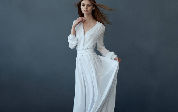 Mujer en el encanto vestido blanco basando el rendimiento de peinado de moda - Foto, imagen