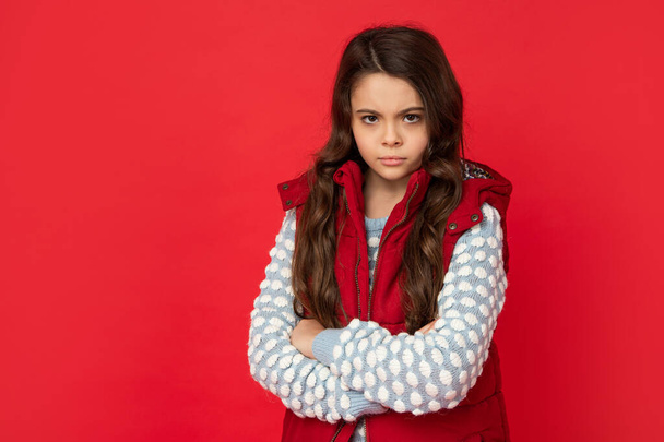 unhappy teen girl in down vest. portrait of child wearing warm clothes. express positive emotion - Foto, Imagen