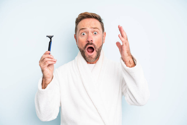 middle age man screaming with hands up in the air. shave concept - 写真・画像