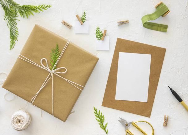 Ручная упаковка рождественских подарков с бумагой. Сверху макет карты xmas, плоская лежала. Зимний фон - Фото, изображение