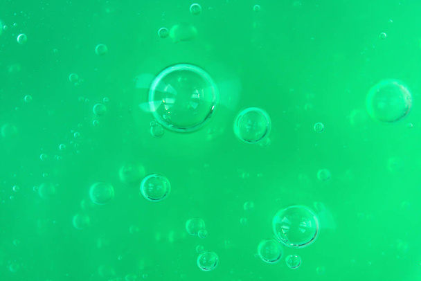Tekstuuri läpinäkyvä vihreä geeli ilmakuplia ja aaltoja vaalea yksivärinen tausta - Valokuva, kuva