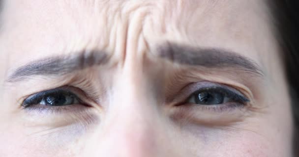 Женщина сильно хмурится и испытывает эмоции страха и дискомфорта замедленной съемки 4К фильма - Кадры, видео