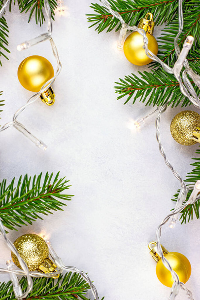 branches de sapin vert, boules dorées et lumières comme décorations saisonnières de Noël sur fond blanc pour les cartes de vœux. Ornement traditionnel de célébration de Noël. - Photo, image