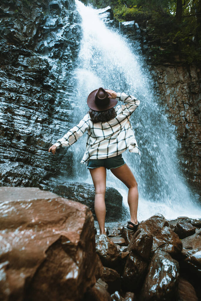 donna in cappello marrone godendo vista della cascata escursionismo concetto di viaggio - Foto, immagini