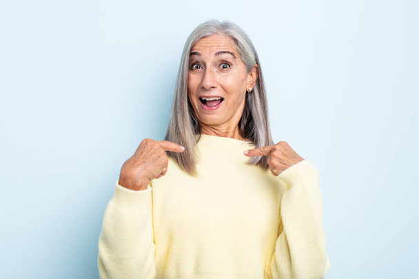 middle age gray hair woman feeling happy, surprised and proud, pointing to self with an excited, amazed look - Fotografie, Obrázek