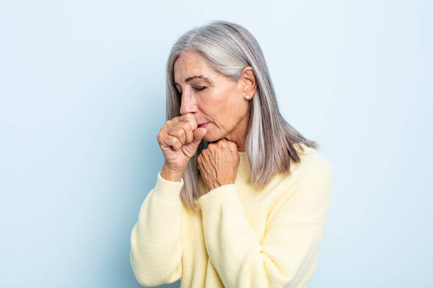 сіре волосся середнього віку жінка відчуває себе погано з болем в горлі і симптомами грипу, кашлем з вкритим ротом
 - Фото, зображення