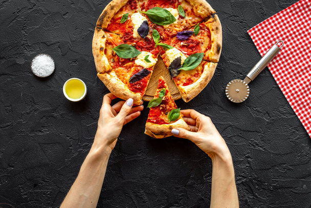 Female hands hold slice of pizza. Overhead view - Photo, Image