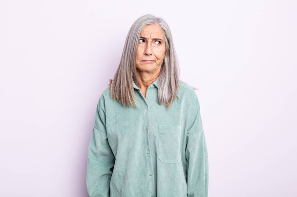 middle age gray hair woman feeling sad, upset or angry and looking to the side with a negative attitude, frowning in disagreement - Фото, изображение