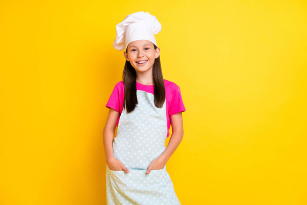 Photo of confident nice girl hands pockets finish dinner wear white apron hat isolated yellow color background - Photo, image