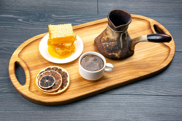 fresh hot coffee with turkey and dried citrus and honeycomb on a kitchen wooden board. useful vitamin food for the human body - Valokuva, kuva